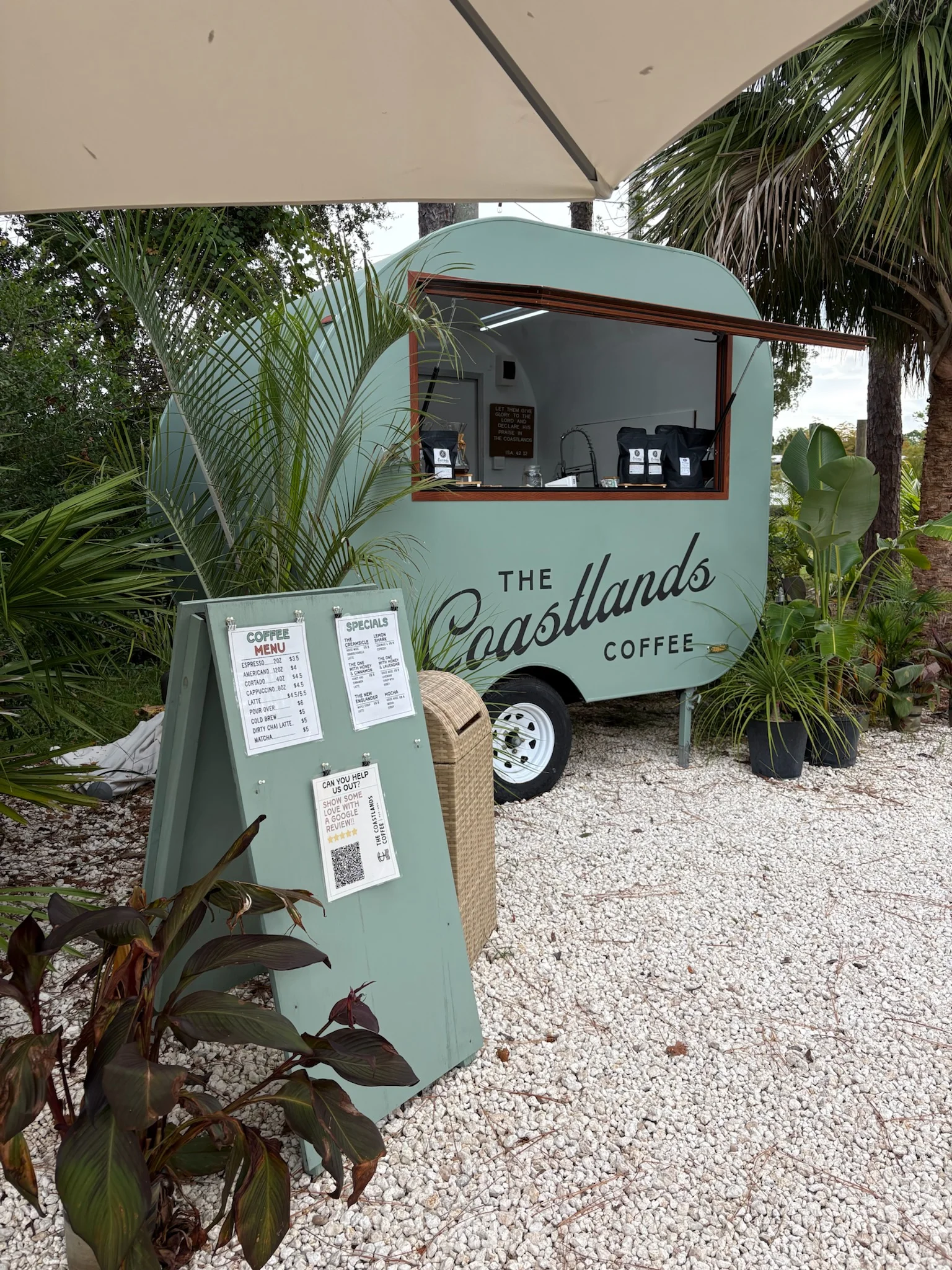The Coastlands service window with menu boards beside the green trailer.